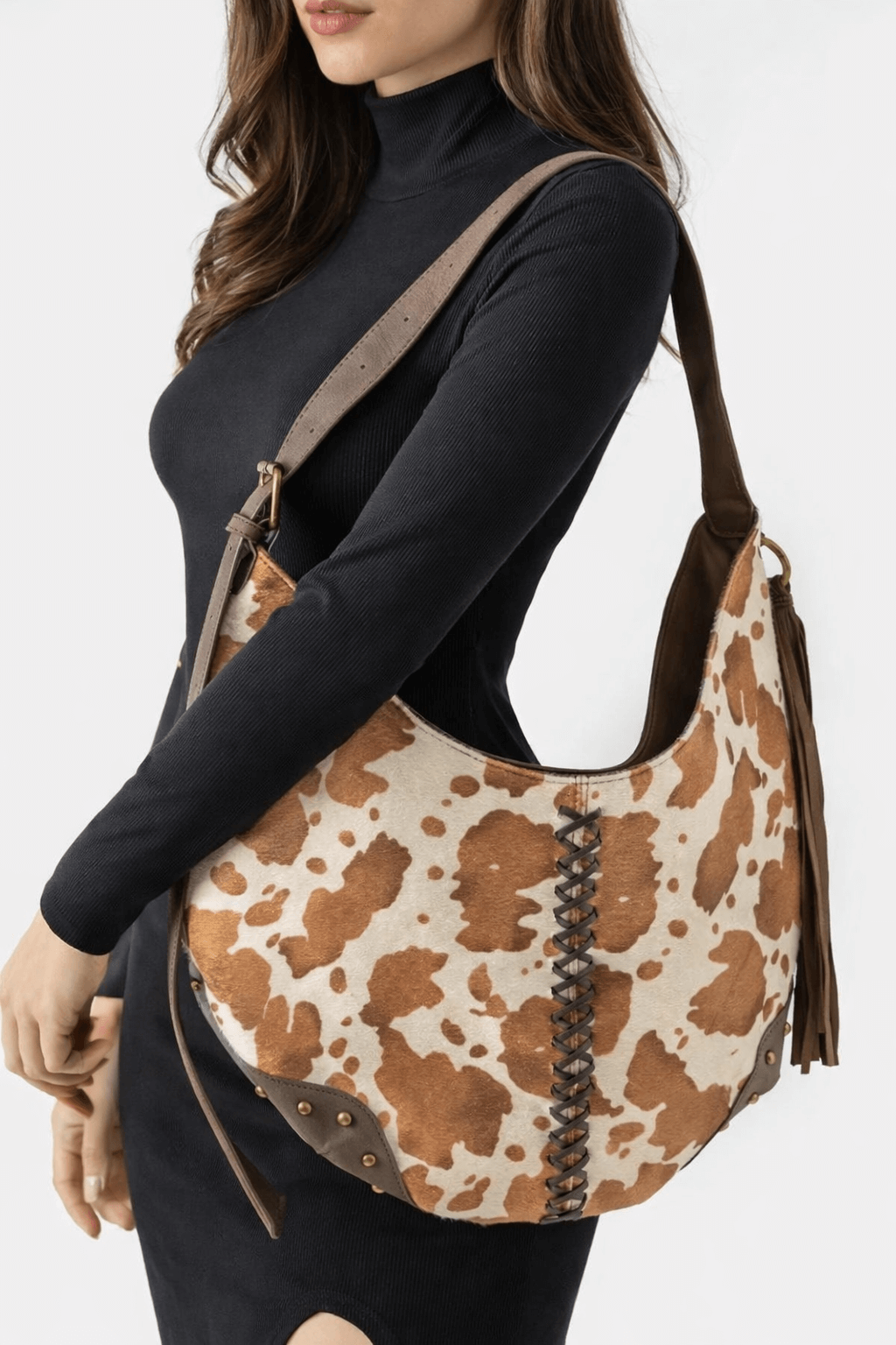 Woman holding a cow print handbag with a white background