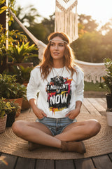 White sweatshirt with a colorful graphic and text 'A Moment of Now' on a white background
