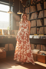 Woman in a floral dress standing in a record store.