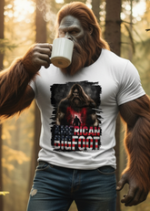 Person in a forest wearing a t-shirt with a graphic design, holding a mug.